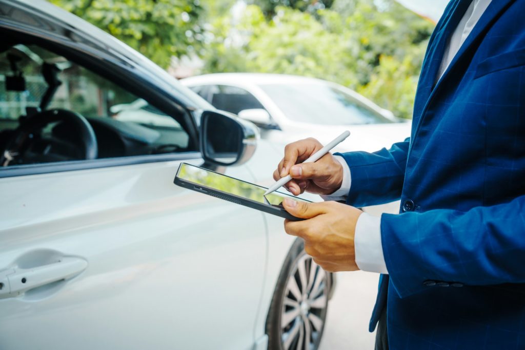 businessman in suit and car auto insurance agent assess car damage, discussing deductible, claims